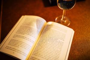 ein offenes Buch neben einem Glas Wein in der Unterkunft Aparthotel Terrassenhof in Bad Wiessee