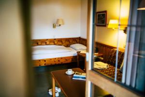 a small bedroom with a bed and a table at Aparthotel Terrassenhof in Bad Wiessee