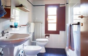 La salle de bains blanche est pourvue d'un lavabo et de toilettes. dans l'établissement Agriturismo Tenuta Vallelunga, à Guasticce