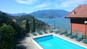 a swimming pool with chairs and a view of the water at Casa Caterina in Varenna
