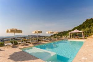 una gran piscina con sillas y sombrillas en Villa Torre en Ripatransone