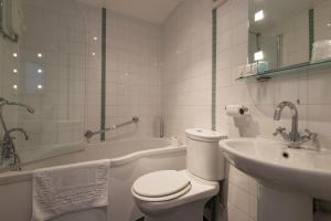 a white bathroom with a toilet and a sink at Green Dragon, Welton by Marston's Inns in South Cave