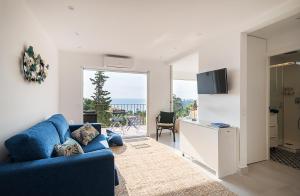 a living room with a blue couch and a view of the ocean at Azteka Blue 2 Bed Apartment Calella de Palafrugell in Calella de Palafrugell