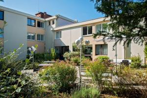 a building with a garden in front of it at Kyriad Nemours in Nemours