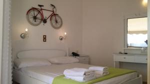 a bedroom with a bed and a clock on the wall at Rachel Hotel in Agia Marina Aegina