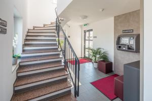 a staircase in a building with a red rug at TRIO Apartment Hotel Berlin in Berlin