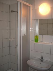 a white bathroom with a sink and a shower at Hotel Krokus in Kamienna Góra