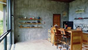 a kitchen with a wooden counter and a bar with stools at COCOON Villa Lamai Koh Samui in Lamai
