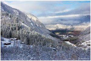 a snow covered mountain with a village in the foreground at Blåtind Apartments in Stordal +2 photos