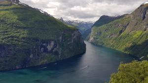 a boat in a river between two mountains at Blåtind Apartments in Stordal
