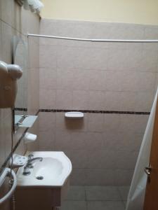 y baño con lavabo blanco y ducha. en Complejo Reliqua Dunamar Claromeco en Balneario Claromecó