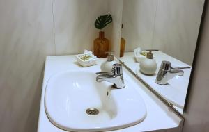 a bathroom with a white sink and a mirror at Blåtind Apartments in Stordal