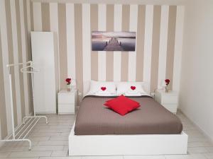 - une chambre avec un lit et 2 oreillers rouges dans l'établissement BSuites Apartment, à Padoue