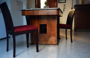 a wooden table with two chairs and a dog house at ArtRoom Garden in Noto