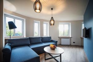 a living room with a blue couch and a table at Apartament Bujwida od WroclawApartament-pl in Wrocław