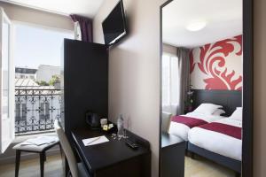 a bedroom with a bed and a desk and a mirror at Hotel Bastille in Paris