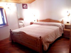 マドンナ・ディ・カンピリオにあるLiving Brenta Apartmentのベッドルーム1室(木製ベッド1台付)