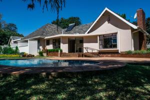 a house with a swimming pool in the yard at Jacaranda in Harare