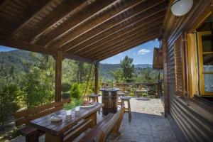 a porch of a house with a table and benches at Ricky Chalet Near Troodos in Spilia
