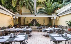 un ristorante con tavoli, sedie e una fontana di Hotel Verona Rome a Roma