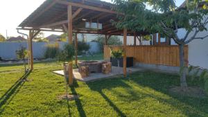 a wooden pavilion in a yard with a tree at Harmónia Vendégház in Poroszló