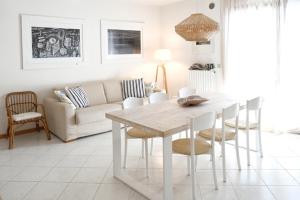 un soggiorno bianco con tavolo e sedie di Sunny Apartment On The Sea a Cavallino-Treporti