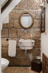 a stone bathroom with a sink and a mirror at PoggioBa in Sovana