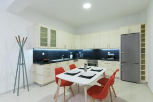 una cucina con tavolo bianco e sedie rosse di Metaxakis Home. 2 a Ierápetra