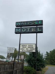 a sign for a waterhole motel with signs on it at The Walpole Motel in Walpole