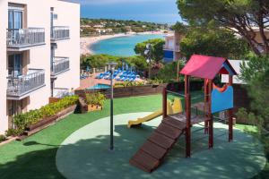 
a park with benches and a pool at GHT S'Agaró Mar Hotel in Sant Feliu de Guíxols
