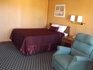 a hotel room with a bed and a chair at Tristar Inn Xpress in Tucumcari