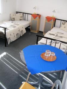 a room with two beds and a table with two glasses on it at Hotel Slovan in Žilina