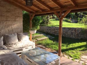 un patio con un sofá bajo una pérgola de madera en Casa Vacacional Altury Valencia, en Turís