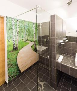 bagno con doccia e murale di alberi di Hotel Rhönhof a Hünfeld