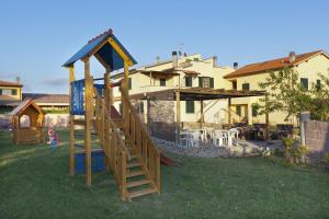 a playground in a yard next to a house at Borgo Guglielmo in Marina di Cecina