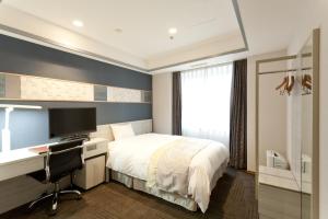 a bedroom with a bed and a desk and a computer at Hotel Tokyo Garden Palace in Tokyo