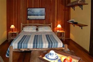 um quarto com uma cama e uma mesa com frutas em Pousada das Fadas em Visconde de Mauá