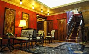 a room with red walls and a staircase and chairs at Villa Hotel in Debrecen