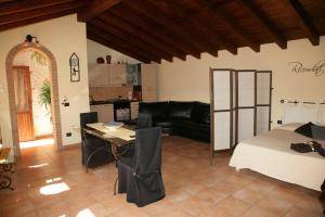 ein Wohnzimmer mit einem Bett, einem Tisch und einem Sofa in der Unterkunft L'Isola Felice Apartment in Monserrato
