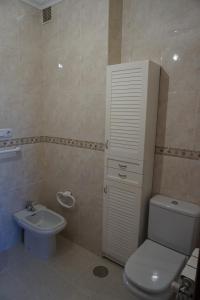 Un baño con un inodoro blanco y un lavabo. en Duplex Ribadeo, en Ribadeo
