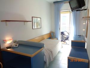 リド・ディ・イエゾロにあるHotel Ambasciatori Palaceのベッドルーム(ベッド1台、デスク、テレビ付)