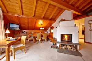 a living room with a fireplace and a wooden ceiling at Hotel Zugspitze in Garmisch-Partenkirchen