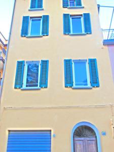 ボローニャにあるLa Petroniana Homeの青い窓とドアの黄色い建物