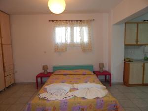 a bedroom with a bed and two tables and a window at Small studio near the center of Tripoli in Tripolis