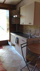a kitchen with a stove and a sink and a table at Chalet Don Bosco in Castiglione di Sicilia