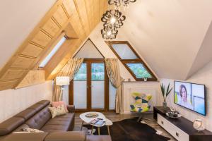 ein Wohnzimmer mit einer Couch und einem Kronleuchter in der Unterkunft PAJO III--Apartament--POLANA SZYMOSZKOWA Ski Resort--STOK NARCIARSKI--GARAŻ PODZIEMNY in Zakopane