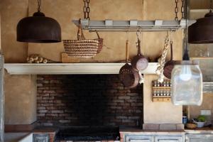 a kitchen with a brick fireplace with pots and pans at Les Bergeries d'Arone in Piana