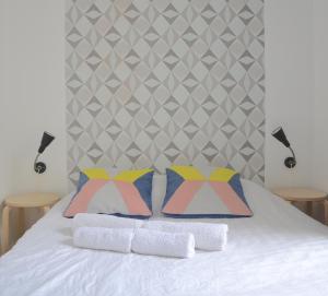 a bed with two pillows and two lamps on it at Longchamp Apartment in Paris