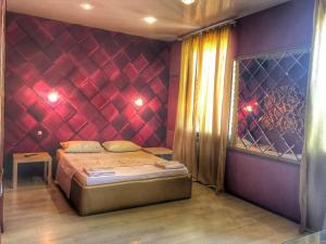 サラトフにあるRoyal Plazaの赤い壁のベッドルーム1室(ベッド1台付)