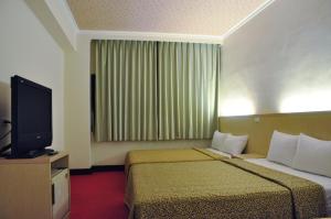 เตียงในห้องที่ Marshal Hotel Taichung名帥大飯店